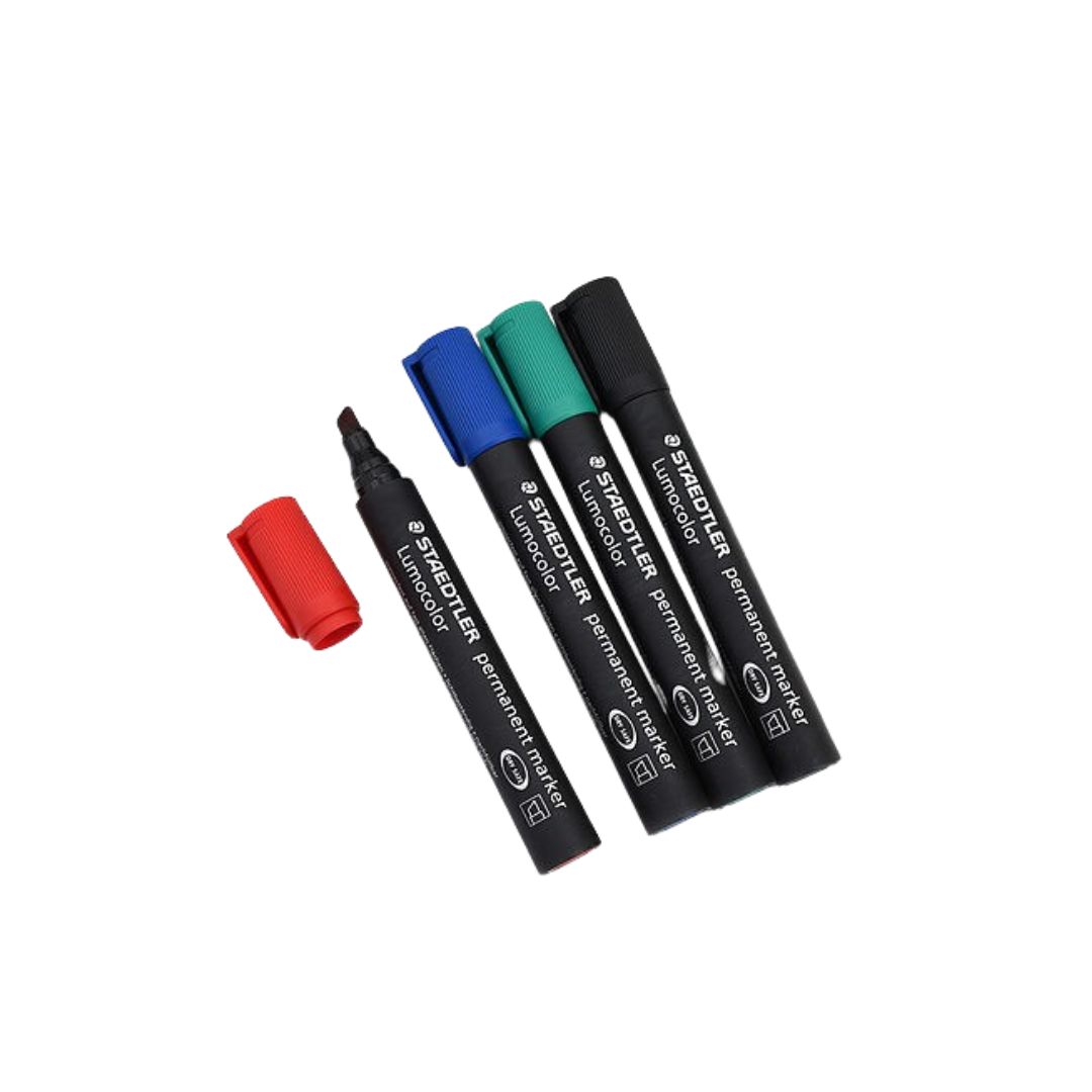 Four STAEDTLER Permanent markers with caps in red, blue, green, and black colors are laid out on a white background